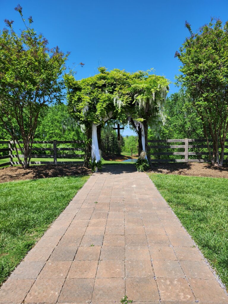 Ceremony site in spring with wisteria bloomingat locally owned wedding venue The Barn at Blueberry Hill in Elkin NC located near Winston-Salem and Charlotte 