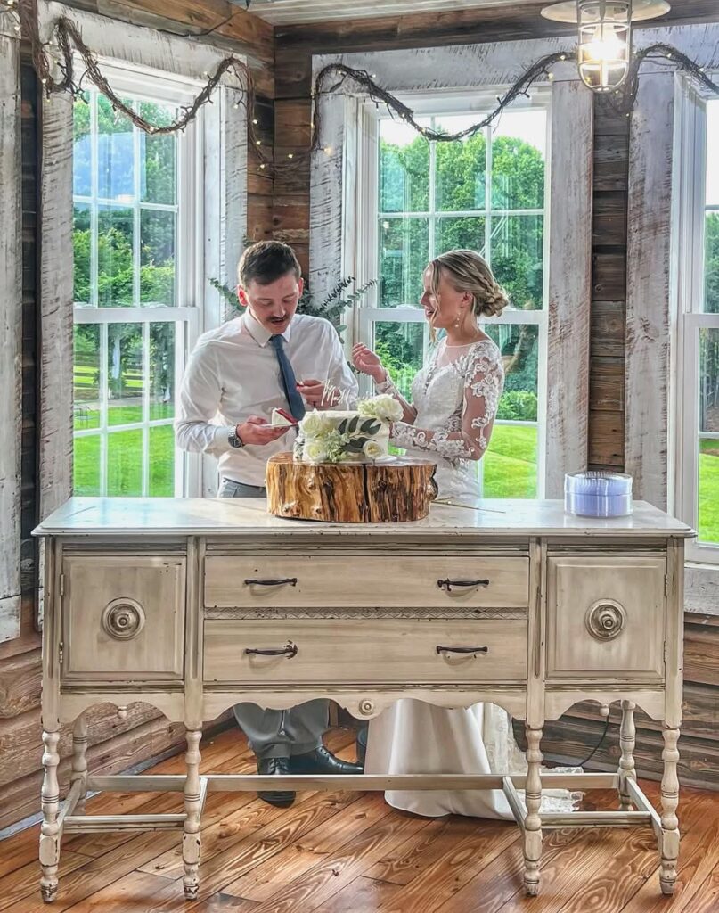 Couple serving wedding cake The Barn at Blueberry Hill a locally owned  wedding venue that includes DJ, bartender and lodging Elkin NC near Winston*Salem and Charlotte